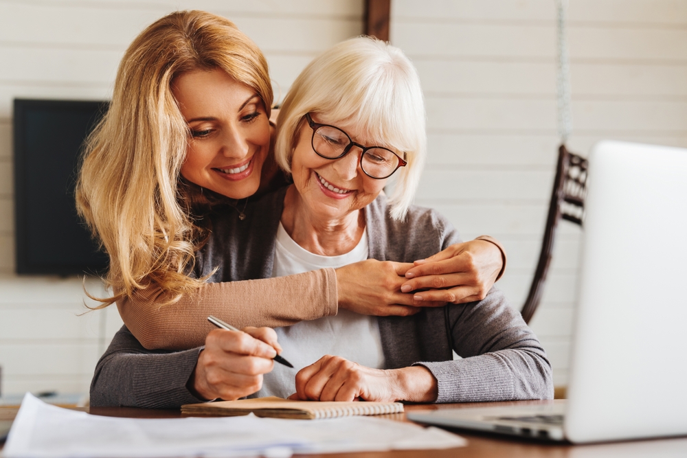 Adult Daughter Helping Senior Woman Complete Form